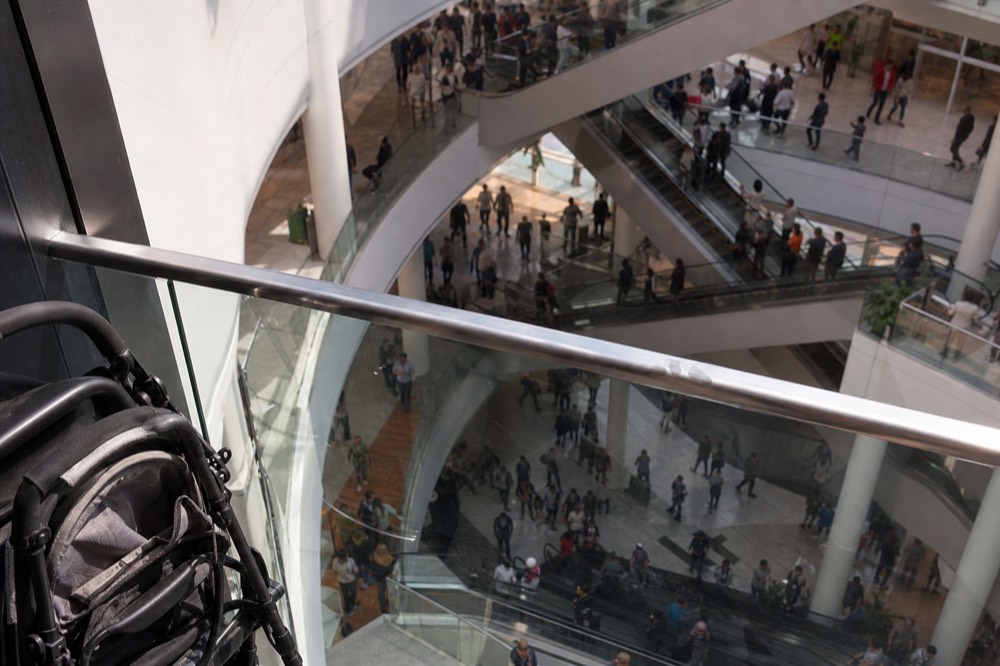 An airy Bangkok shopping mall atrium with escalators, no text, no logos, no people.