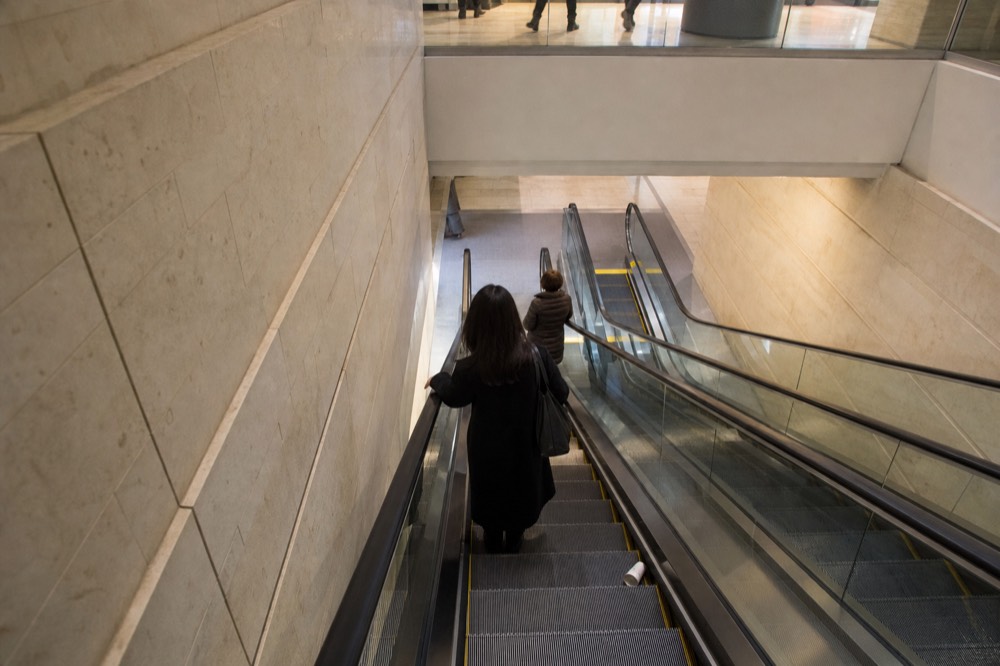 Interior of a large Bangkok shopping mall with escalators descending to a basement level, no text, no logos, no people.